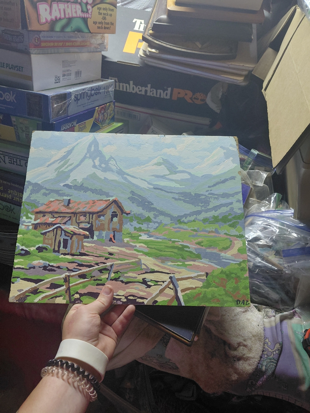 vintage Paint by Number landscape painting featuring a rustic cabin and snowy mo